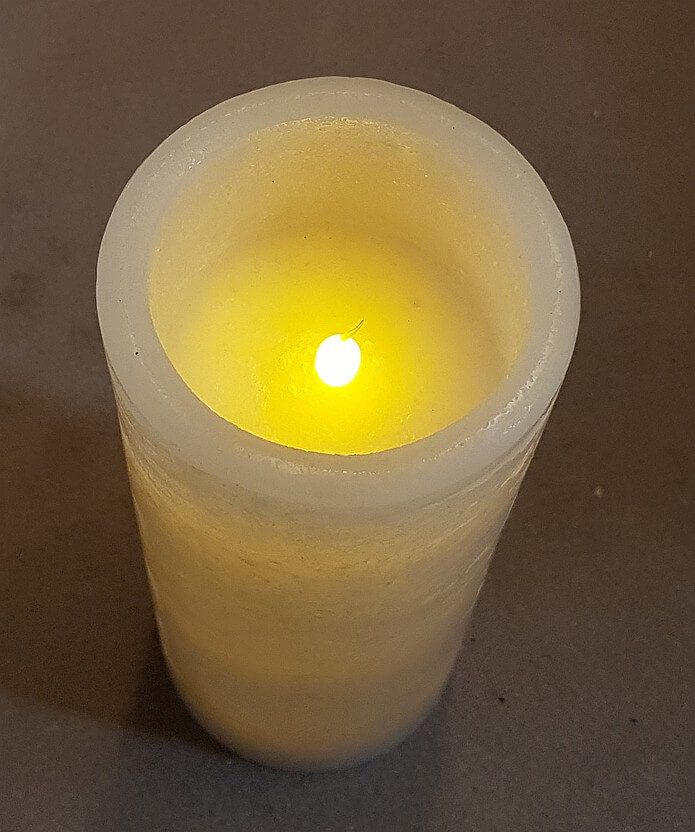LED-Kerze in Betrieb mit Kunststoffflamme und Echtwachs-Gehäuse