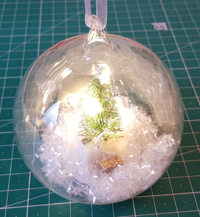 Weihnachtliche Glaskugel mit Tannenbaum und LEDs
